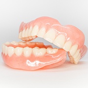Full set of dentures unevenly placed one over the other on a white background