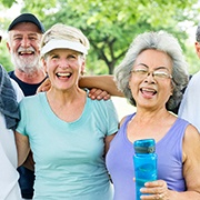 Diverse group of older adults working out together outside smiling